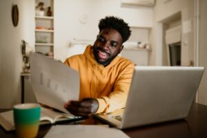 A cheerful african american casual entrepreneur is looking at statistics