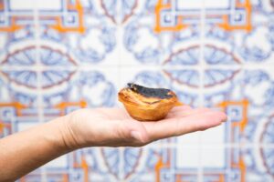 A hand holding a pastel de nata in Lisbon, Portugal.