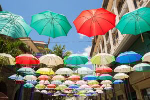 Multi-colored umbrellas background. Colorful umbrellas floating above the street. Street decoration