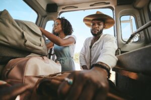 Travel luggage, black couple and car road trip together love bonding on nature safari holiday in Af